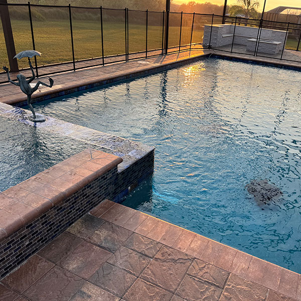 Beautiful new pool in the backyard with a hot tub at sunset in Lithia, FL